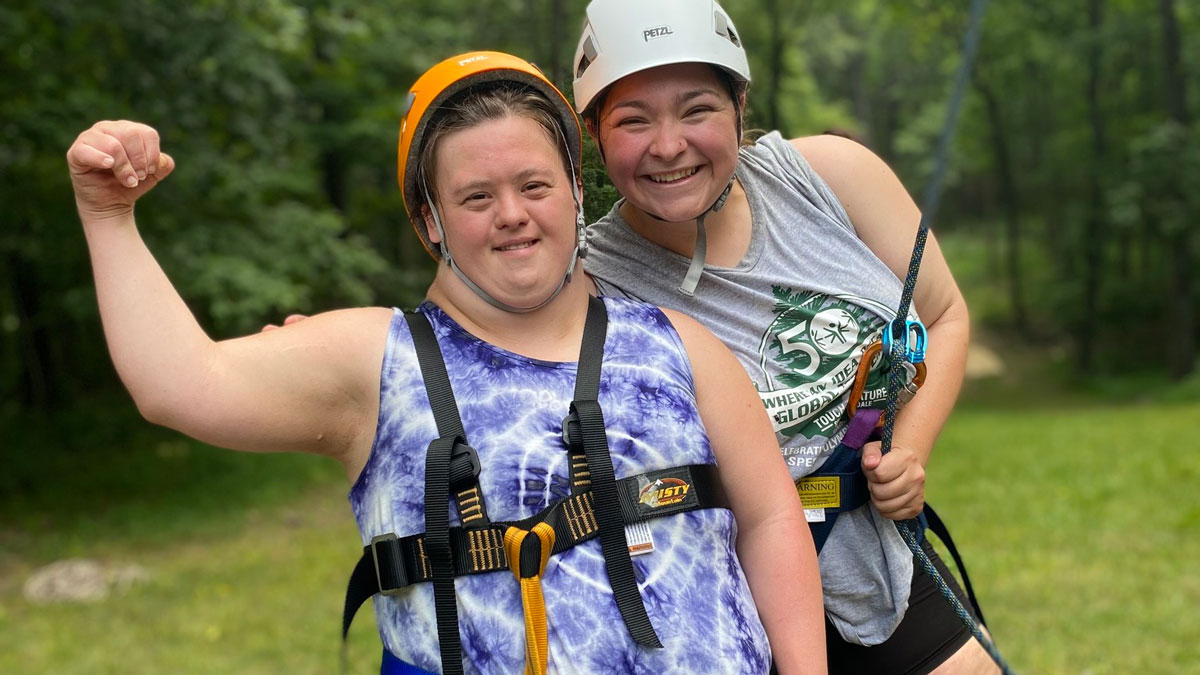 A camper and counselor pause for a picture while ziplining.