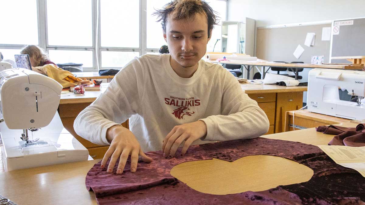 A student is seen working on a sewing project